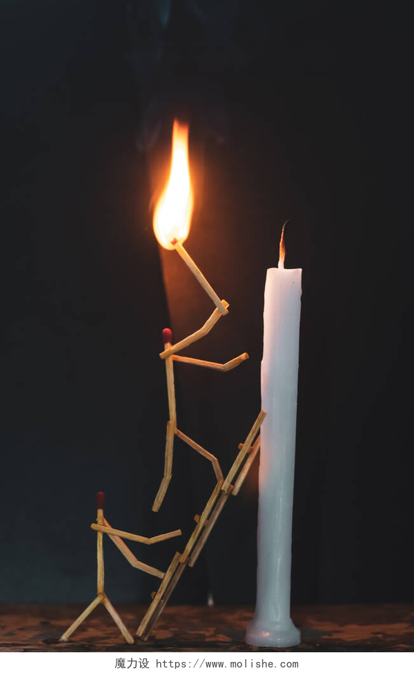 黑色背景上的蜡烛和人形状的火柴.火柴棍的形状是男人点燃蜡烛，火柴棍的形状是男人点燃蜡烛.